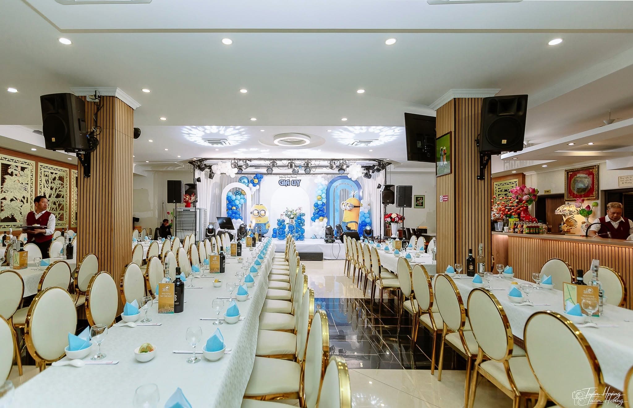Banquet hall arranged for a celebration with stage, lights and decorated tables