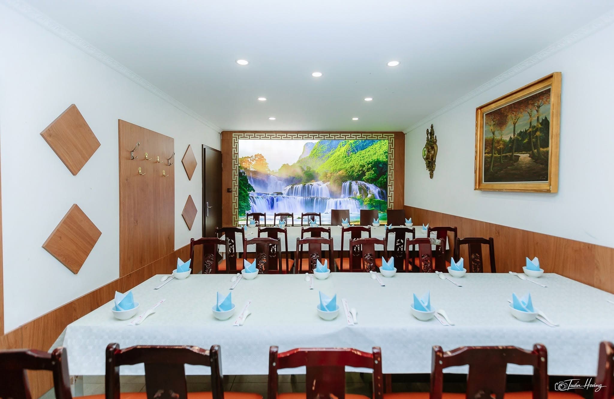 Private dining room prepared with long tables and blue folded napkins